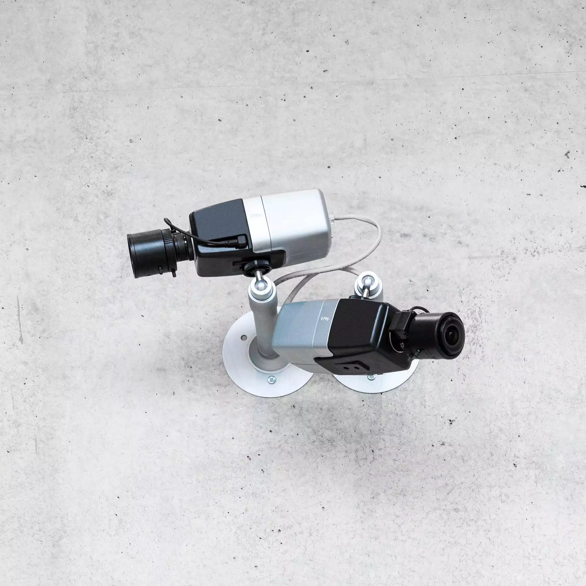 Two modern cctv security cameras on concrete wall